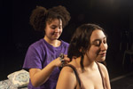 Theater student in purple shirt putting a necklace on another student