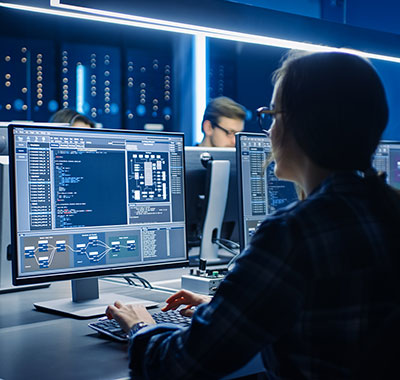 women sitting at a computer screen with a technical display