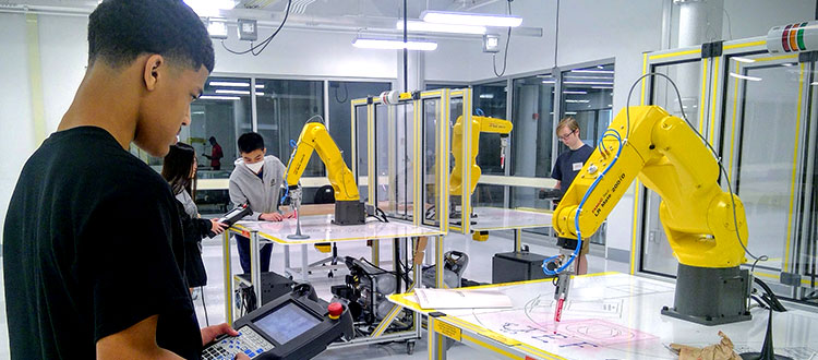 Student working in robotics lab with a robotic arm