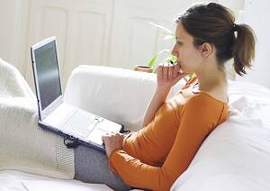 Student working on her laptop on her couch