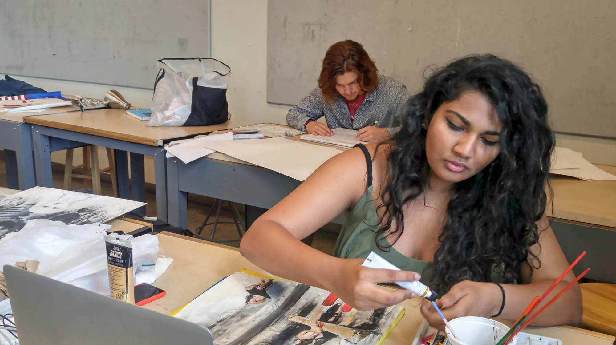 Two students draw in an art classroom at MCC