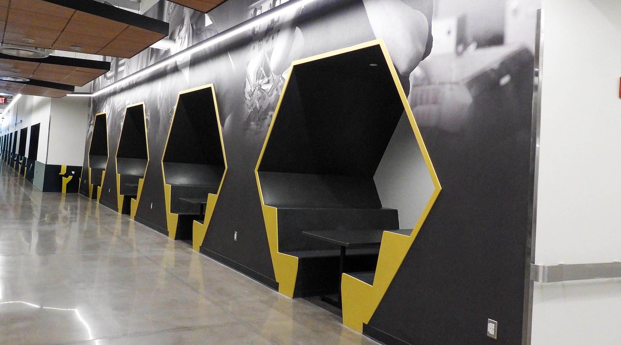 Modern study booths line a college hallway, offering students private spaces for studying or collaborating.