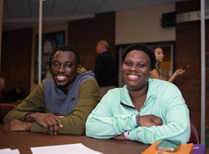 2 students smiling behind a table of candy
