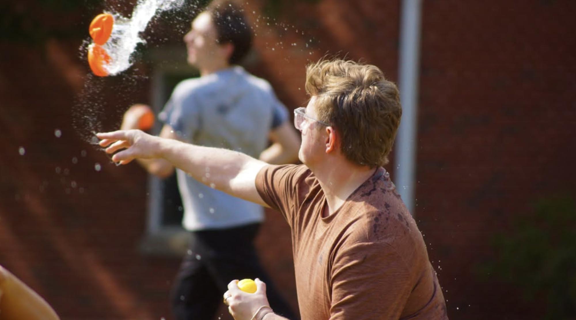 action shot of a student throwing a water balloon