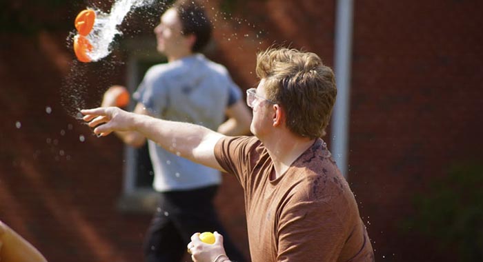 2 people in a water balloon fight